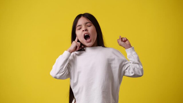4k video of one girl who wants to sleep and yawns over yellow background.
