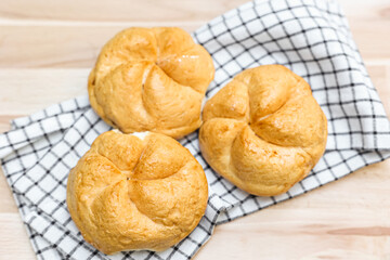 Kaiser rolls with napkin on table, closeup