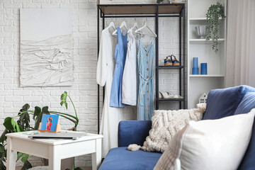Shelving unit with clothes in interior of light room