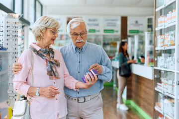 Fototapeta na wymiar Senior couple buying medicine in pharmacy.