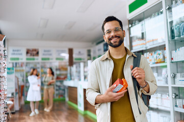 Portrait of happy man buying in pharmacy and looking at camera.