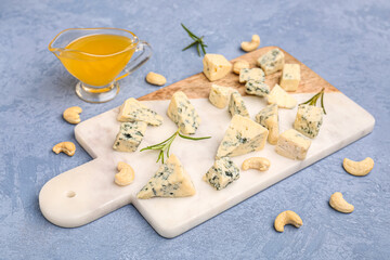 Board with pieces of tasty cheese on grey background