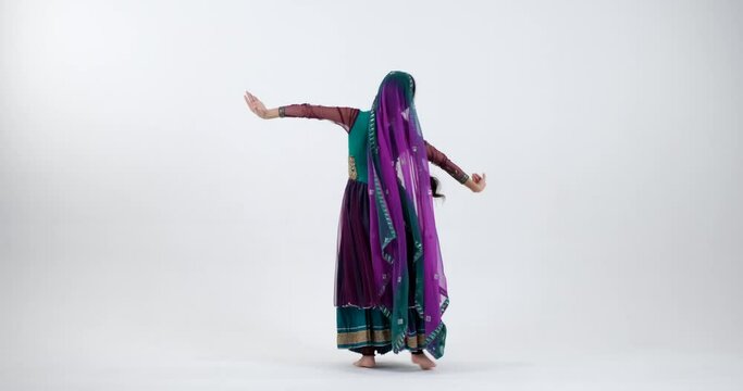 Feel the energy and joy of Bollywood dancing as a young Indian woman dances passionately in a stunning sari with bright colors and patterns, creating an electrifying performance.