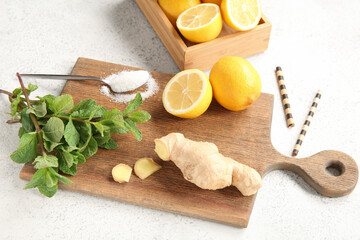 Wooden board and box with ingredients for preparing lemonade on grunge white background