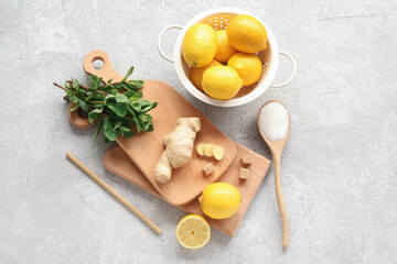 Wooden boards with lemons, mint and ginger on grunge grey background