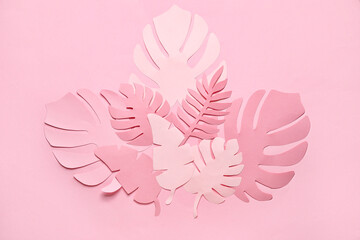 Different paper tropical leaves on pale pink background
