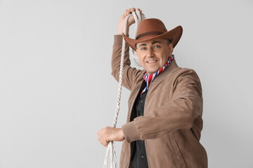 Mature cowboy on light background
