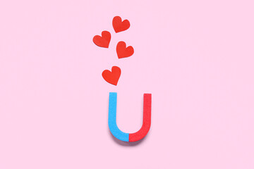 Magnet with paper hearts on pink background. Love concept