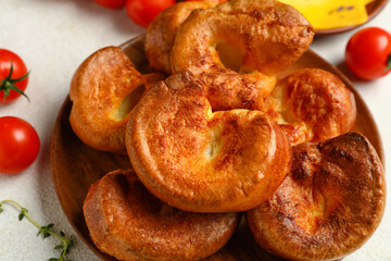 Plate with tasty Yorkshire pudding on light background
