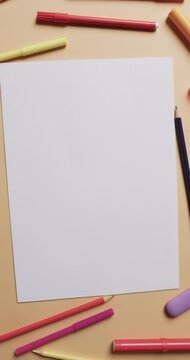 Vertical video of close up of blank sheet of paper on beige background, in slow motion
