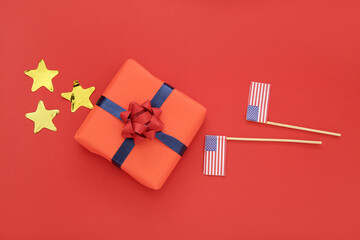 Gift box with USA flags and stars on red background. American Independence Day