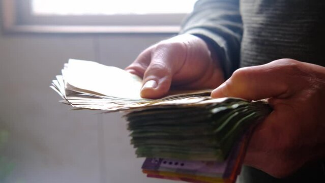 man holds, counts lot of national currency of Sri Lanka, paper money bills Rupee banknotes, devaluation, high inflation of state, exchange rate on travel, vacation, savings, banking, tax payment