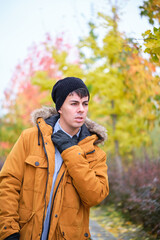 Young man in pain suffering sore throat on a cold autumn day.