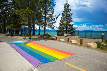 Pride Flag painted on sidewalk in South Lake Tahoe for Pride Month, with view of the South West...