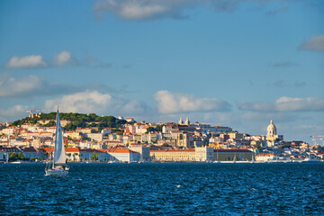 Fototapeta na wymiar View of Lisbon over Tagus river from Almada with yachts tourist boats on sunset. Lisbon, Portugal