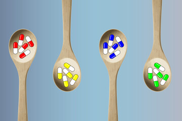 Colorful pills-capsules of medicines, vitamins or supplements in wooden kitchen spoons on a gray background. Concept of medicine and health	