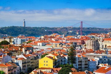 Fototapeta na wymiar Lisbon famous view from Miradouro dos Barros tourist viewpoint over Alfama old city district, 25th of April Bridge and Christ the King statue. Lisbon, Portugal.