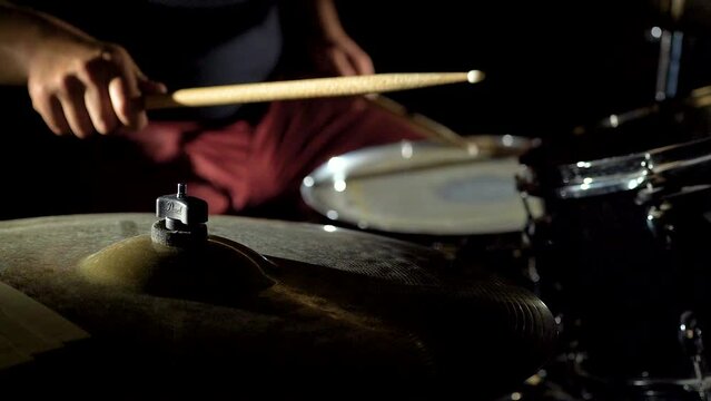 Hands of professional drummer musician is playing hitting drum kit and cymbals