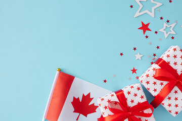 Happy Canada day concept. Top view photo of gift boxes in national colors, flag, red maple leaves and white red stars on light blue background with empty space for text or ad - obrazy, fototapety, plakaty