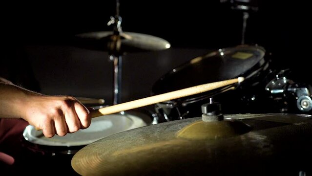 Hands of unrecognizable musician drummer are playing hitting drums and cymbals.