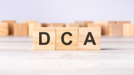 DCA - word concept written on wooden cubes or blocks on a light background