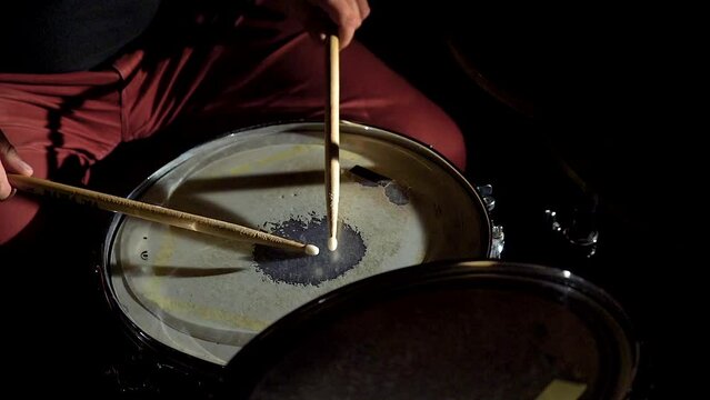Unrecognizable musician man drummer is playing hitting drum on drums kit.