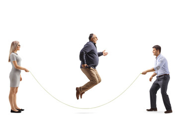 Full length profile shot of young man and woman holding a rope and mature man jumping