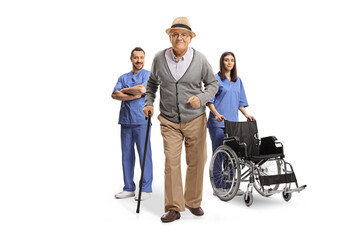 Elderly man with a walking cane in front of team of health care workers