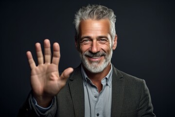 Fototapeta premium Medium shot portrait photography of a satisfied mature man making a money gesture rubbing the fingers against a dark grey background. With generative AI technology