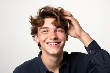 Headshot portrait photography of a happy boy in his 20s putting the hand on the forehead to look for someone in the distance against a pearl white background. With generative AI technology