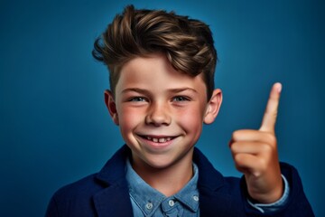 Headshot portrait photography of a grinning boy in his 30s making a peace gesture with two fingers against a sapphire blue background. With generative AI technology
