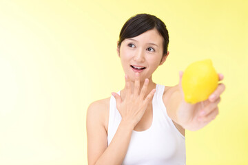 Obraz na płótnie Canvas レモンを持っている笑顔の女性
