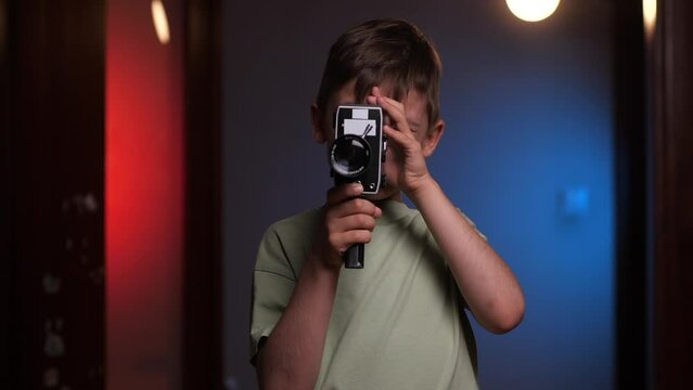 portrait of a boy shoots video on an old vintage 8mm camcorder