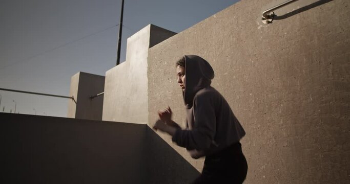 Strong female fighter shadowboxing on street