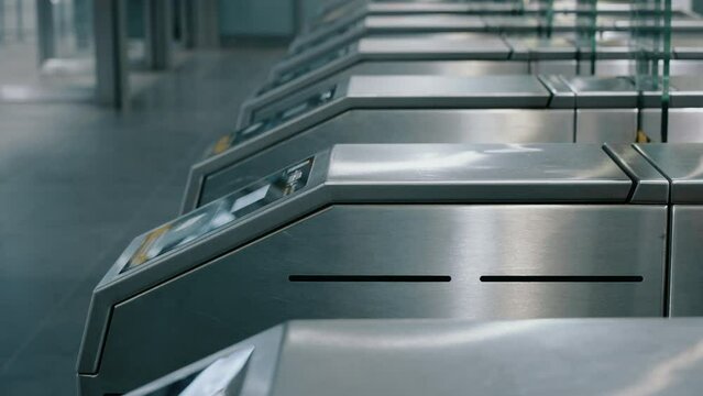 Lot of people passengers going through automatic turnstiles in subway station, entrance tourniquet to metro railway train platform. Ticket scanner. Long exposure, time-lapse blurred fast motion