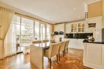 a dining room with wood flooring and an open door leading out to the kitchen, living room and dining area