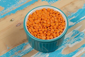 bowl with red lentils on rustic blue wooden table