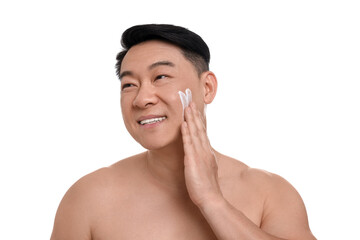 Handsome man applying cream onto his face on white background