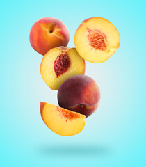 Juicy fresh peaches falling on light blue background