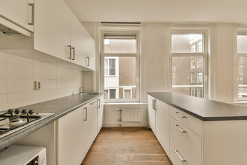 an empty kitchen with white cabinets and black counter tops in front of the window looking out to the street outside