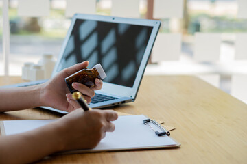 Female doctor with laptop working at table Portrait of Asian female doctor working with patient papers in her office at clinic close up photo