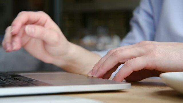 Close up of female hands typing on modern laptop keyboard making notes writing on device