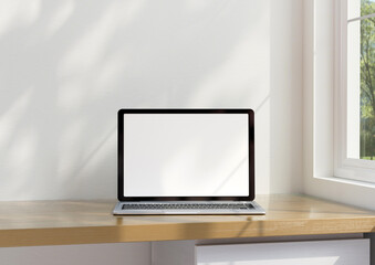 A laptop mockup on the table In the warm office at home, there was light coming through the window. with clipping path. 3d rendering