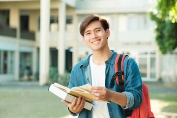 Student standing outdoor and holding books.