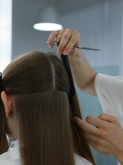 hairdresser creates a haircut for long natural hair, using Vidal Sassoon techniques, hairline 