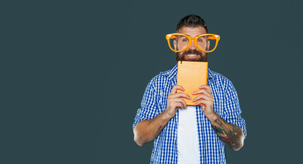 positive funny bearded man in party glasses hold book