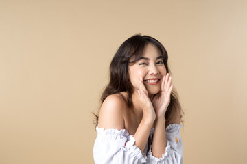 Fototapeta na wymiar Young Asian woman doing a shocked surprise gesture shouting with hands cupped around mouth isolated brown color background