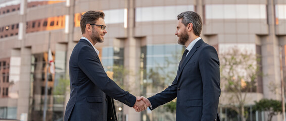 two businessmen deal with handshake. two businessmen deal with handshake outdoor.