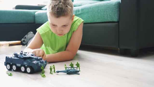 Boy Play Soldier Mini Figure Toy  in the Lihgt Room. Close Up Child Face Playing With Toy Soldiers. Small Boy Plays With Miniature Combat Figurines. Concept of Play Games, Military, War and Battle.