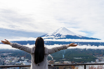 Happy Asian woman enjoy outdoor lifestyle travel Japan on autumn holiday vacation. Attractive girl tourist travel lake Kawaguchi and looking beautiful nature of mt Fuji covered in snow in winter day